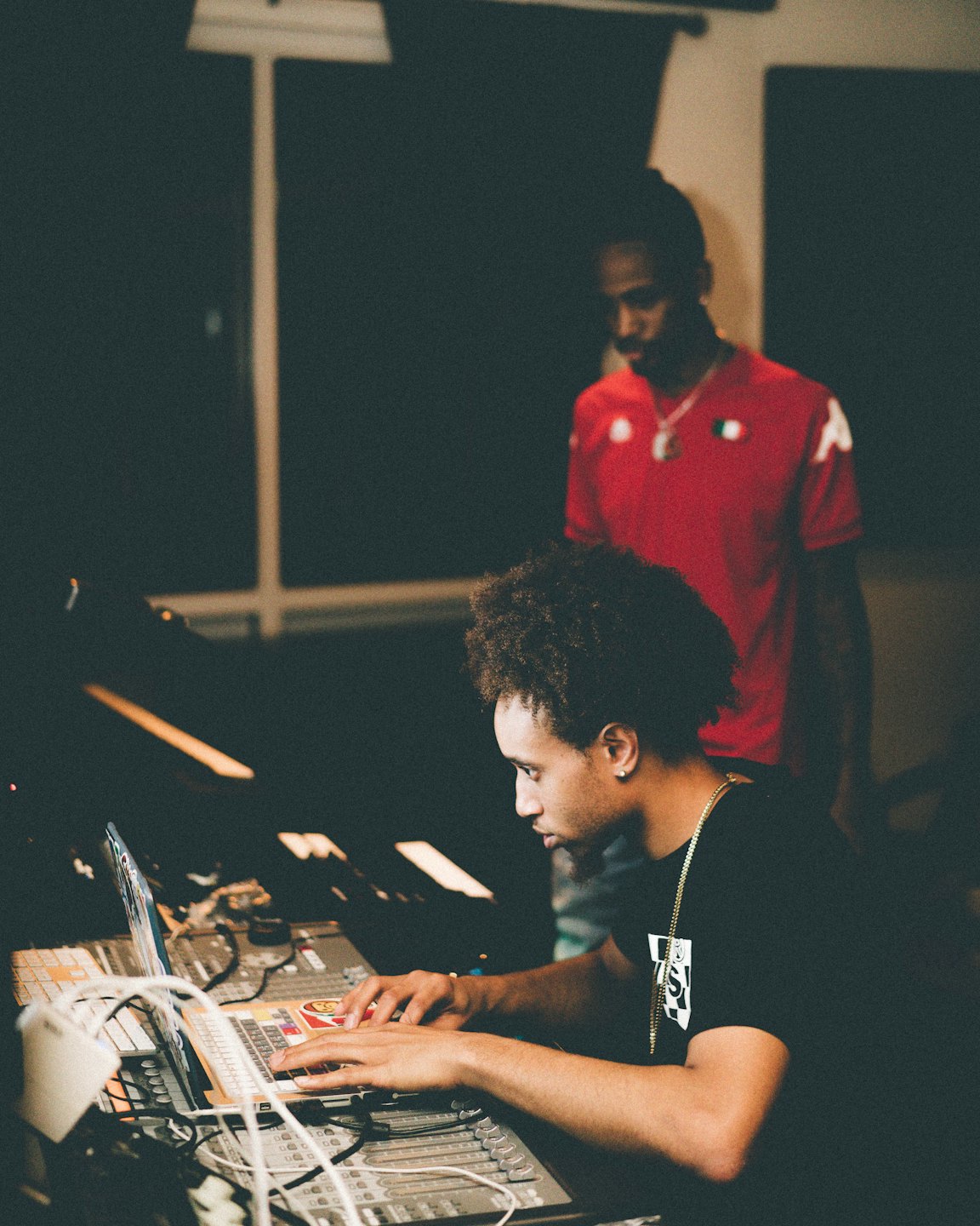 Two music producers working together at a mixing console.