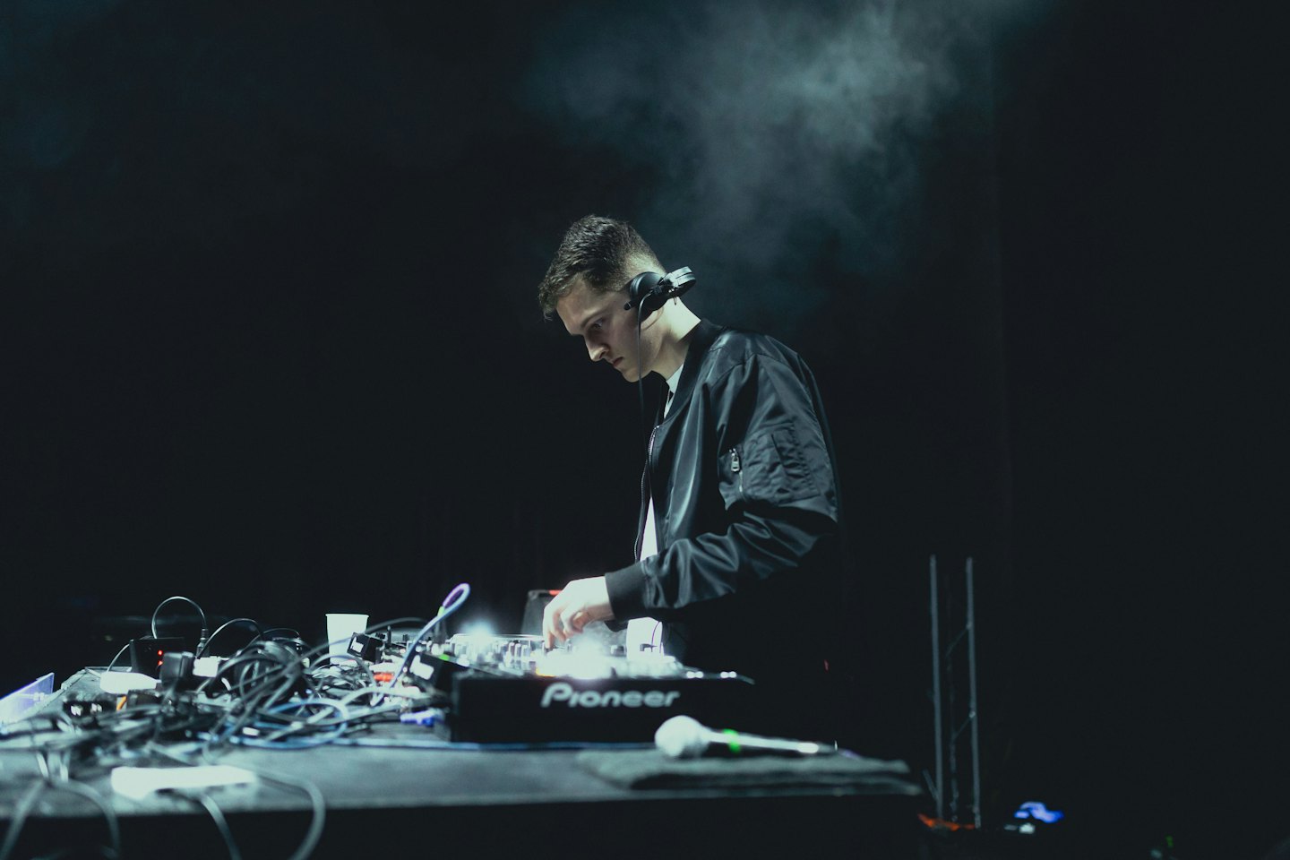 DJ wearing headphones mixing music on turntables.