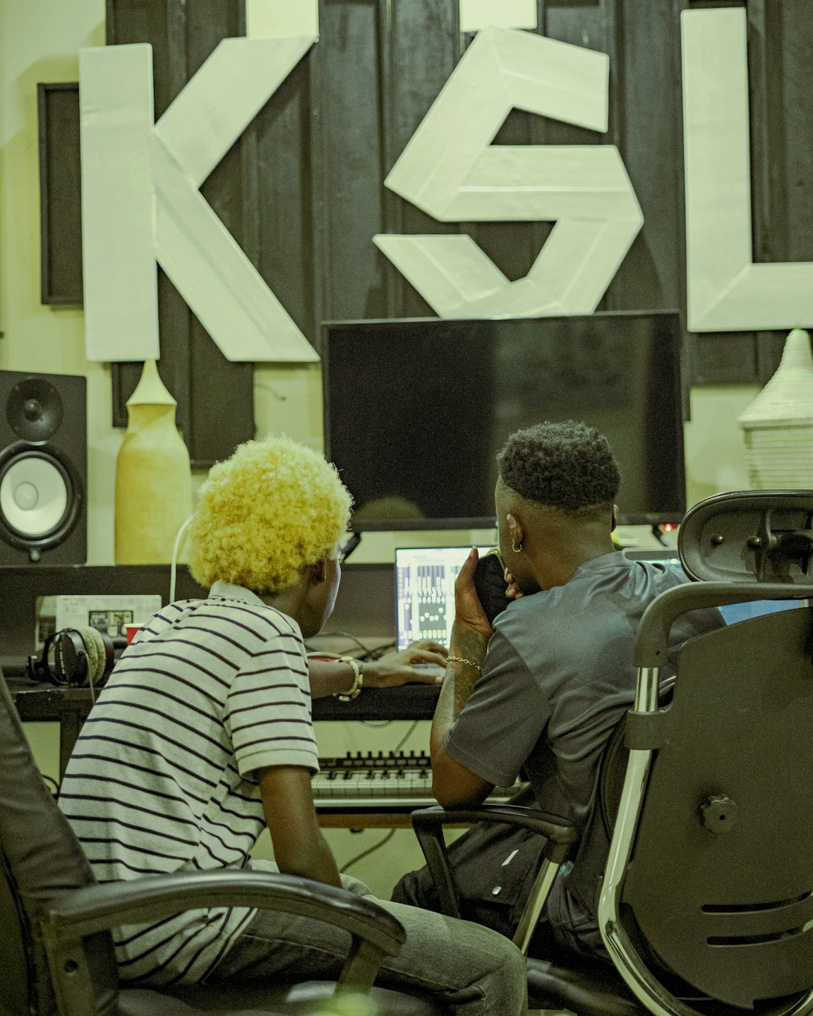 Two music producers working together in a professional recording studio.
